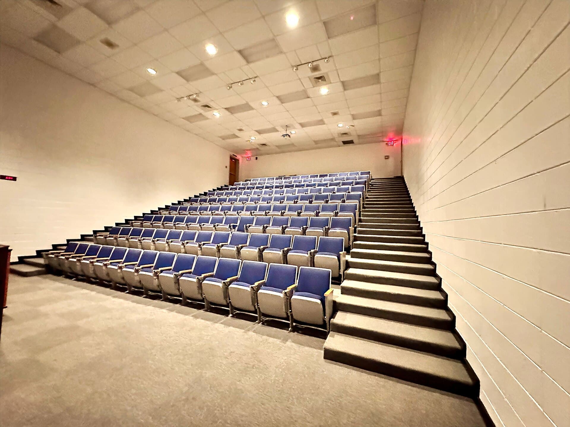Aula magna con gradas de asientos azules